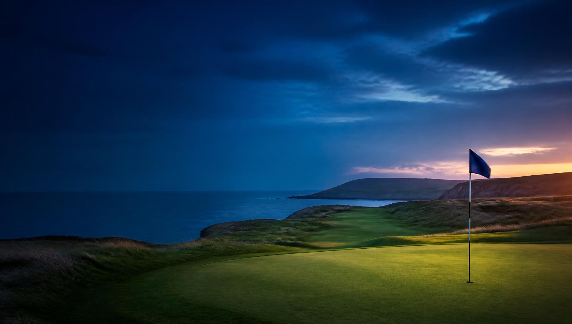 Coastal golf course with a green and flag at dusk